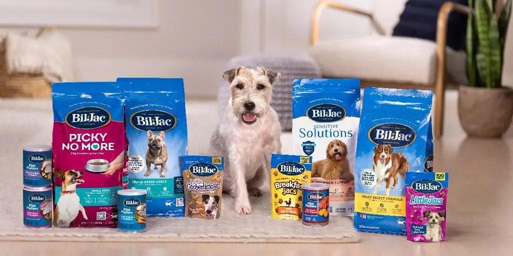 A Jack Russell with a variety of Bil-Jac Dog Food and Treat products.