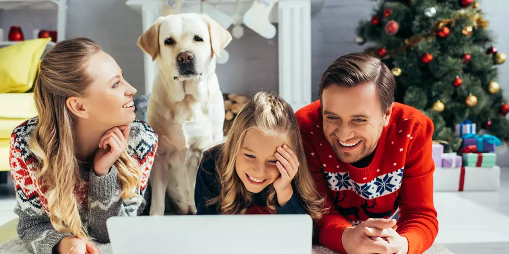 A family laughing while reading Christmas dog puns.